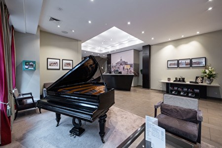 lobby van het hotel met piano, zitplaatsen en receptiedesk