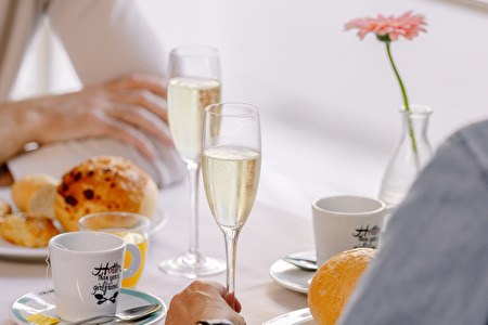 Twee mensen aan tafel met champagne en koffie
