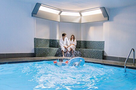 koppel op relaxbank, kinderen in het zwembad